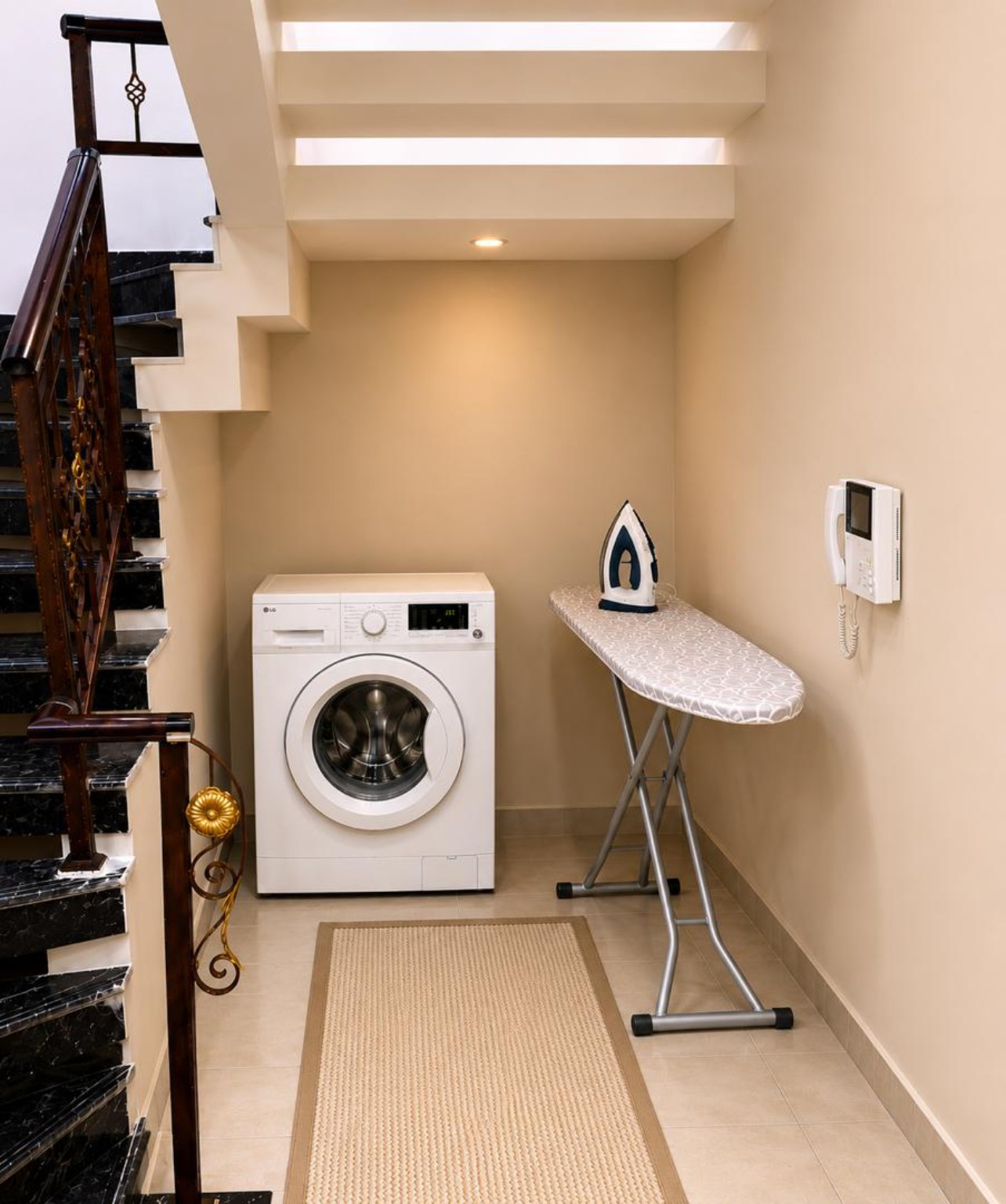 Washer and ironing board in a Kiniz apartment